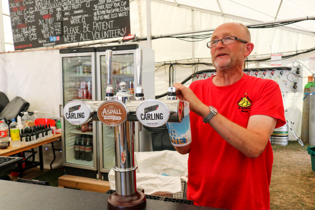 Swanage Carnival volunteer pouring a pint at the beer tent