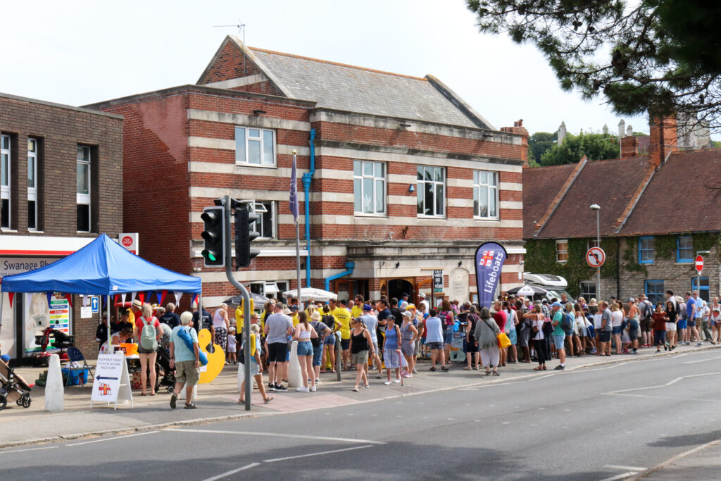 Crowd outside Swanage Con Club awaiting RNLI duck race