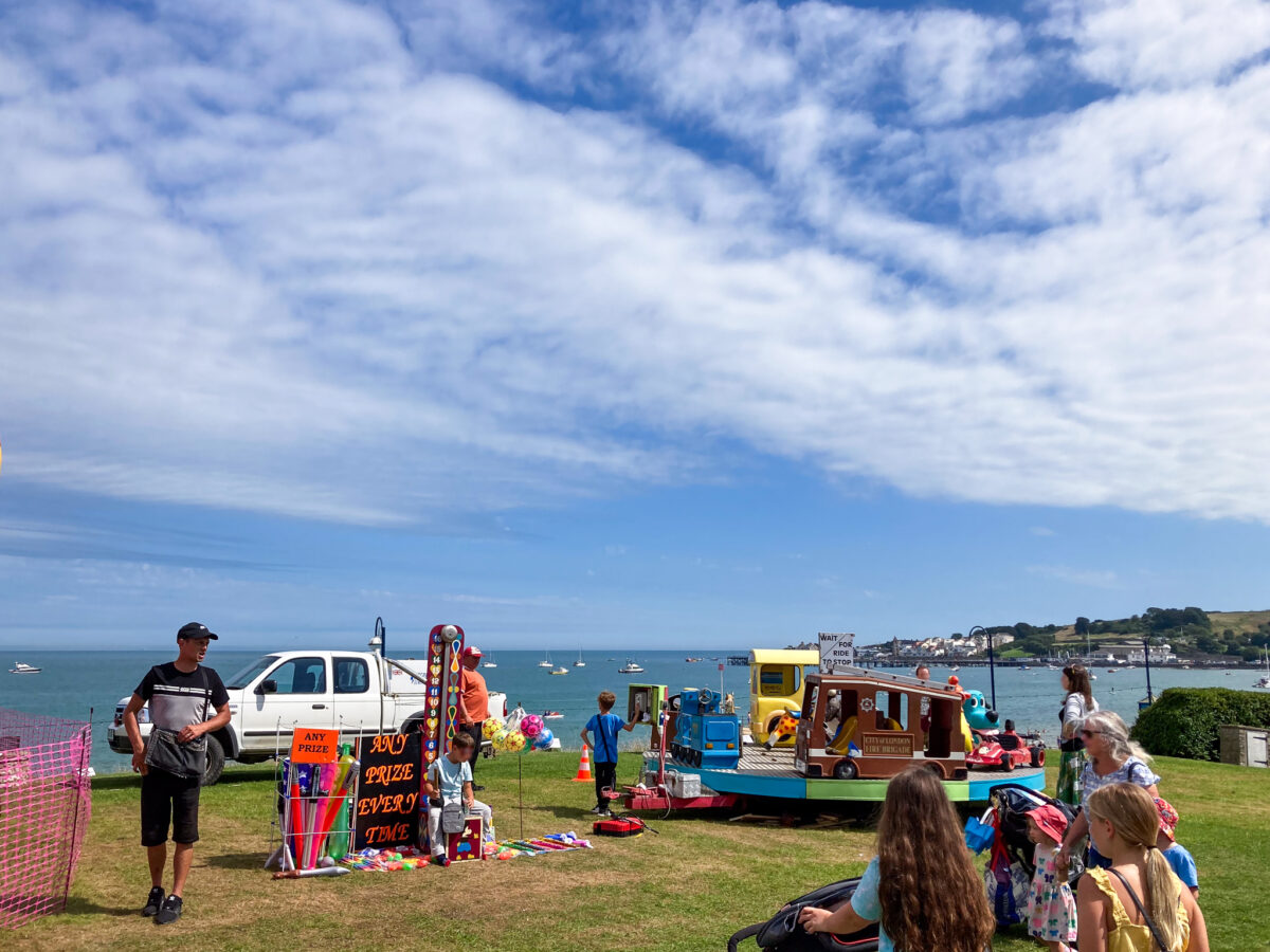 Children's fairground game and roundabout ride by Swanage Bay